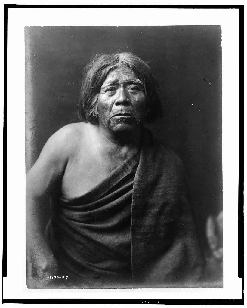 [Mat Stams--Maricopa, half-length portrait, facing front, wrapped in…, 1907
