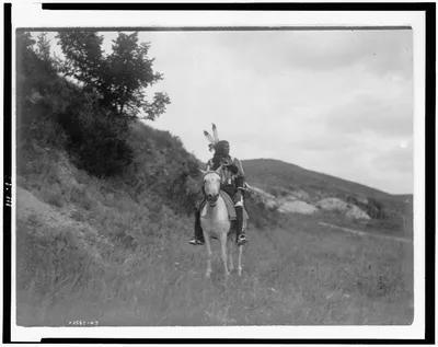 [Sioux Indian on horseback, wearing two feathers, beaded buckskin…, 1907